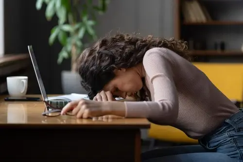 woman putting her head down on desk