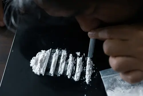 person snorting cocaine lines on a table