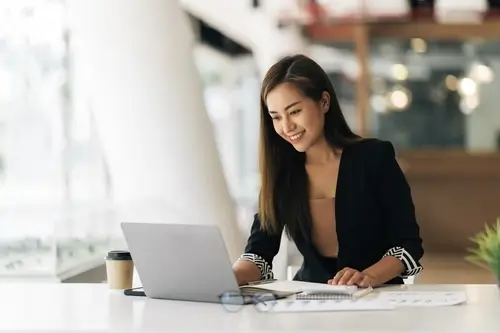 woman smiling in front of laptop