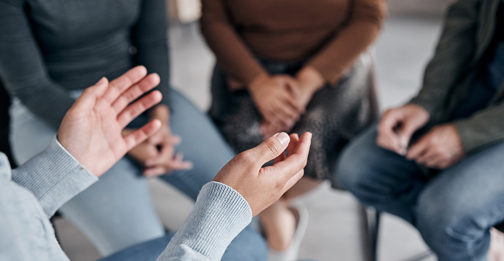 A group of people talk at a mental health treatment center.